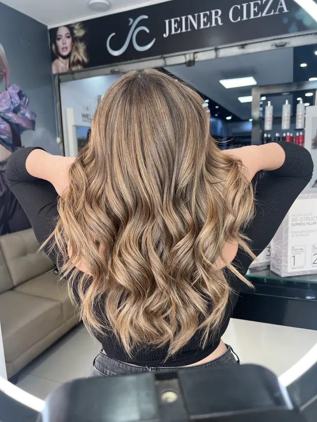 Balayage beige en ondas, pelo largo, bajo el letrero de Jeiner Cieza